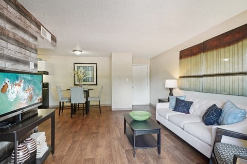 A living room with a white couch and a wooden coffee table.